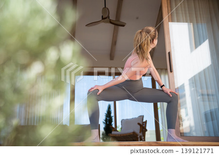 Fit caucasian woman practicing Yoga stretching on luxury home terrace Fit caucasian woman practicing Yoga stretching on luxury home terrace 139121771