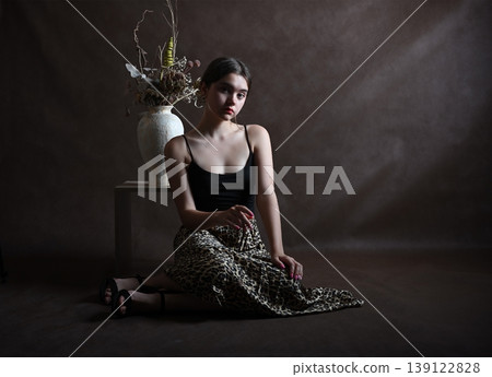 Teenage girl with dark hair poses in the studio looking at the camera Teenage girl with dark hair poses in the studio looking at the camera 139122828