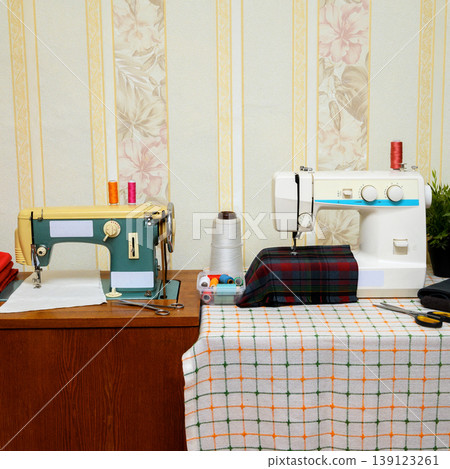 front view of two sewing machines on a table in an atelier front view of two sewing machines on a table in an atelier 139123261