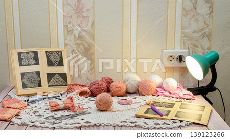 frontal view of a table with crochet and knitting supplies frontal view of a table with crochet and knitting supplies 139123266