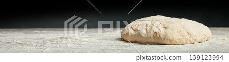 Raw dough on floured table with copy space, side view Raw dough on floured table with copy space, side view 139123994