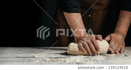 Baker kneading dough on floured table artisanal bread making process with hands and copy space 139124018