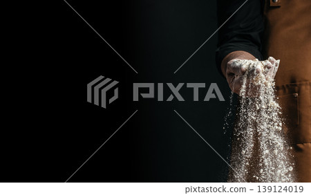 Hand sprinkling flour with falling particles on dark background, artisan baking concept with copy space Hand sprinkling flour with falling particles on dark background, artisan baking concept with copy space 139124019