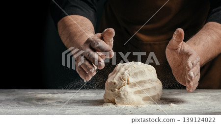 Baker hands shaping dough with flour dust on dark background artisan bread making concept Baker hands shaping dough with flour dust on dark background artisan bread making concept 139124022