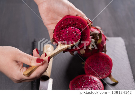 Dragon fruit and hands on grey granite floor. Dragon fruit and hands on grey granite floor. 139124142