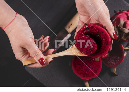 Dragon fruit and hands on grey granite floor. Dragon fruit and hands on grey granite floor. 139124144