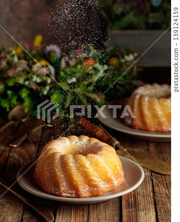 Traditional vanilla pound cake with orange extract and spring flowers on an old wooden table. Traditional vanilla pound cake with orange extract and spring flowers on an old wooden table. 139124159