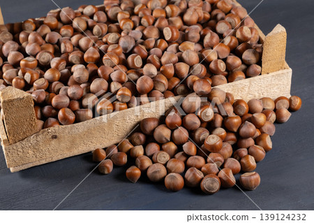 Pile of hazelnuts in a wooden crate. 139124232