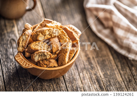 Rustic Almond Biscotti cantuccini in Ceramic Bowl With Coffee Cup on Weathered Wooden Table 139124261