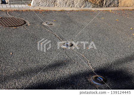 Retractable hydraulic bollard point ( Car barrier ) In unused mode on street pavement Retractable hydraulic bollard point ( Car barrier ) In unused mode on street pavement 139124445