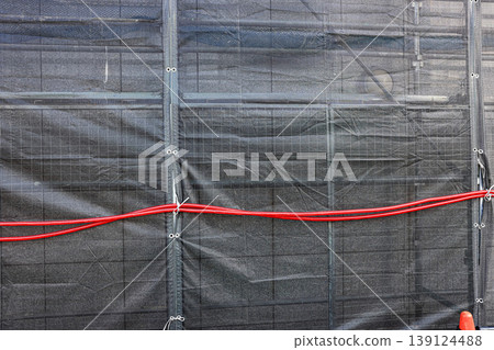 Covered facade of a reconstruction building, Scaffolding with safety nets during renovation building. Covered facade of a reconstruction building, Scaffolding with safety nets during renovation building. 139124488