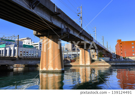 A concrete railway bridge with massive pillars stretching across Murasaki river, Japan. A concrete railway bridge with massive pillars stretching across Murasaki river, Japan. 139124491