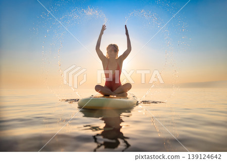 Young woman walking on sup board by the sea during summer vacation Young woman walking on sup board by the sea during summer vacation 139124642