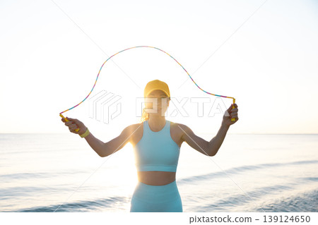 Fit woman jumping rope at the beach during summer vacation 139124650