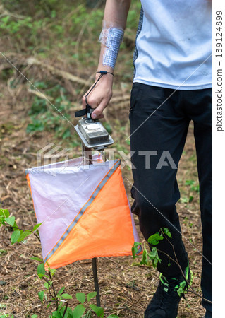 Close-up of an orienteer punching an electronic control 139124899