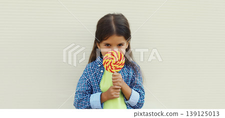 Happy cheerful smiling child, little girl with sweet lollipop Happy cheerful smiling child, little girl with sweet lollipop 139125013