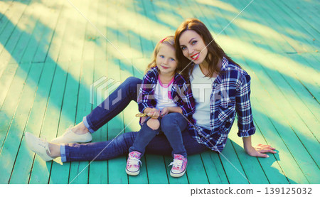 Stylish mother and child daughter together, happy mom with kid girl in the city Stylish mother and child daughter together, happy mom with kid girl in the city 139125032