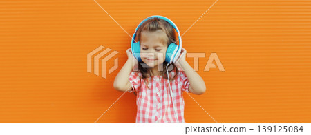 Happy little girl child in headphones listening to music Happy little girl child in headphones listening to music 139125084