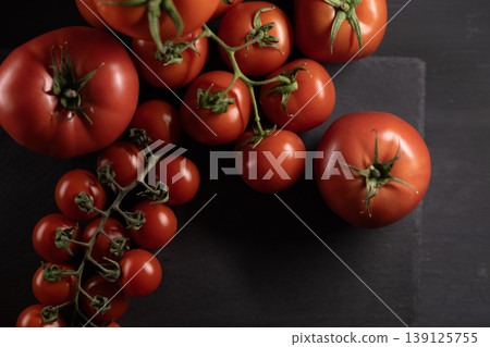 Organic red tomatoes for sale at farmers market. Fresh tomatoes displayed at local market stall. Organic red tomatoes for sale at farmers market. Fresh tomatoes displayed at local market stall. 139125755