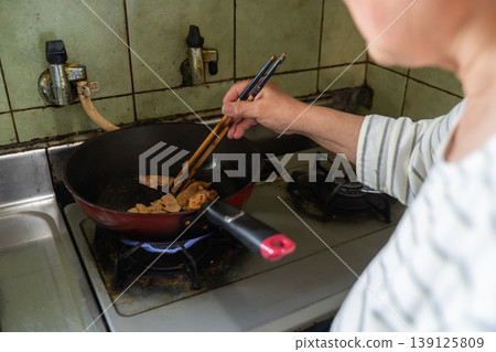 Woman cooking in a frying pan Woman cooking in a frying pan 139125809