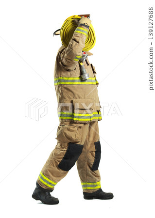Firefighter in full protective suit carrying fire hose 139127688