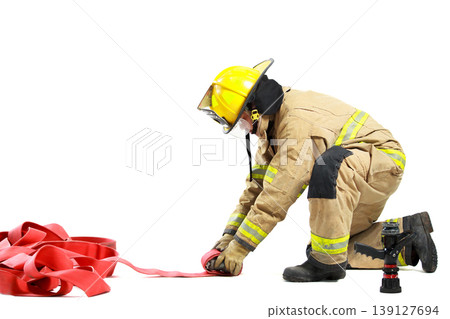 Professional firefighter kneeling and organizing equipment for duty Professional firefighter kneeling and organizing equipment for duty 139127694