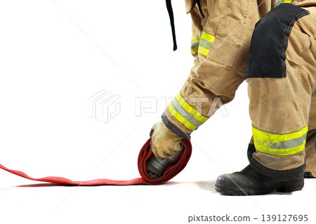 Professional firefighter kneeling and organizing equipment for duty Professional firefighter kneeling and organizing equipment for duty 139127695