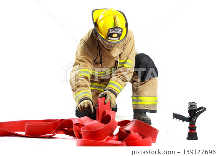 Professional firefighter kneeling and organizing equipment for duty Professional firefighter kneeling and organizing equipment for duty 139127696