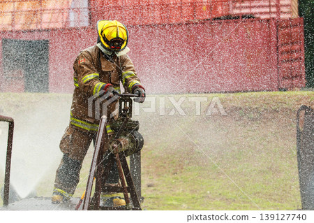 Firefighter turning water valve during outdoor training session Firefighter turning water valve during outdoor training session 139127740