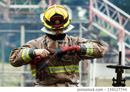Firefighter removing safety gloves after emergency operations Firefighter removing safety gloves after emergency operations 139127744