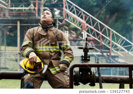 Exhausted Asian firefighter resting after finishing a rescue mission Exhausted Asian firefighter resting after finishing a rescue mission 139127745