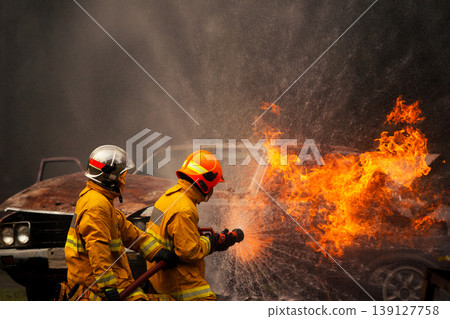 Firefighters putting out intense car fire with water spray Firefighters putting out intense car fire with water spray 139127758