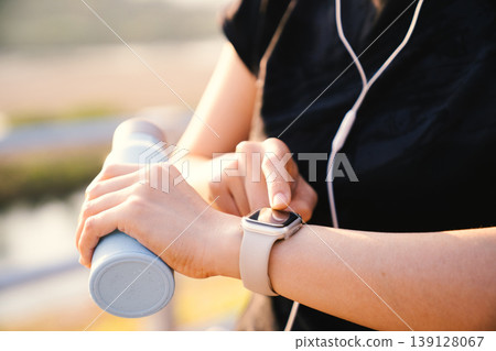 Close up of Asian woman using smartwatch during outdoor workout Close up of Asian woman using smartwatch during outdoor workout 139128067