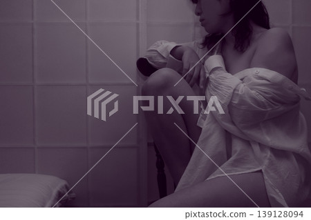 一位身穿白襯衫的女子坐在椅子上。 一位身穿白襯衫的女子坐在椅子上。 139128094