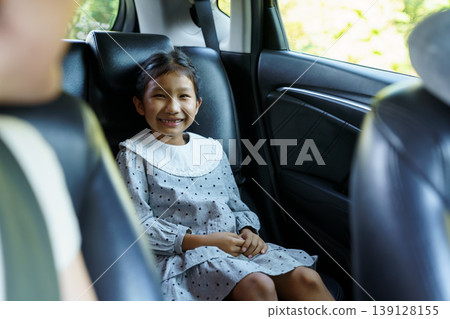 Happy Asian girl cheering in car back seat during family road trip Happy Asian girl cheering in car back seat during family road trip 139128155