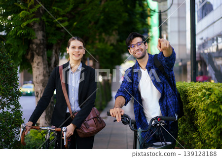 Business people with bicycles walking in urban environment. 139128188