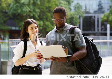 Business colleagues working together on laptop in urban area 139128211