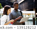 Business colleagues working together on laptop in urban area 139128212