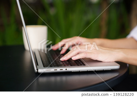Close up woman hands typing on laptop in modern workspace 139128220