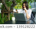 Woman working remotely on laptop in modern outdoor workspace 139128222