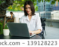Woman working remotely on laptop in modern outdoor workspace 139128223
