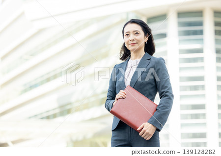 拿著筆記本微笑的女商人 139128282