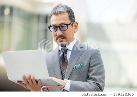Senior businessman operating a laptop Senior businessman operating a laptop 139128300