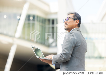 Senior businessman operating a laptop Senior businessman operating a laptop 139128301