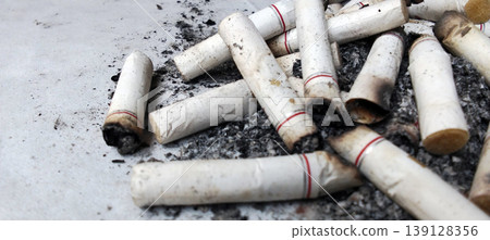 Pile of Cigarette Butts and Ash on Dirty Surface Pile of Cigarette Butts and Ash on Dirty Surface 139128356