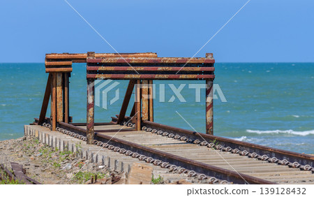 Rusty railway pier end of the line at Talaimannar, Sri Lanka, overlooking the Indian Ocean with abandoned tracks and coastal seascape under the clear blue sky Rusty railway pier end of the line at Talaimannar, Sri Lanka, overlooking the Indian Ocean with abandoned tracks and coastal seascape under the clear blue sky 139128432