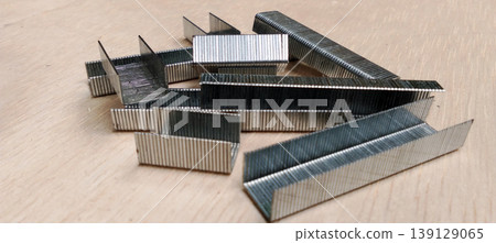 Stack of Metal Staples on Wood Surface Stack of Metal Staples on Wood Surface 139129065
