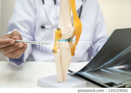 Doctor examining knee joint bone radiography xray film. Doctor examining knee joint bone radiography xray film. 139129092