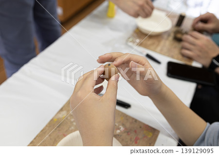 Children's hands enjoying crafting by processing nuts and seeds in a workshop. Children's hands enjoying crafting by processing nuts and seeds in a workshop. 139129095