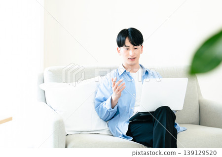 A man who uses a personal computer in the living room A man who uses a personal computer in the living room 139129520